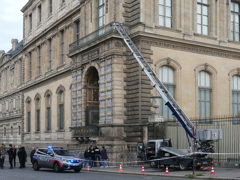 Französische Polizisten neben einem Möbelaufzug, der für den Raubüberfall auf das Museum Louvre in Paris verwendet wurde.