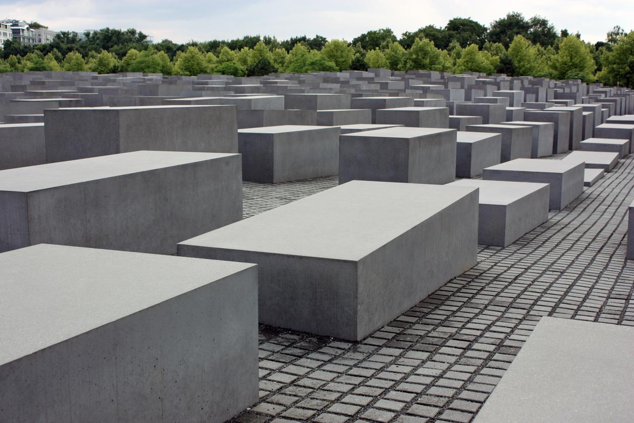Die grauen Stehlen des Holocaust-Mahnmals in Berlin stehen auf einem großen, gepflasterten Platz.