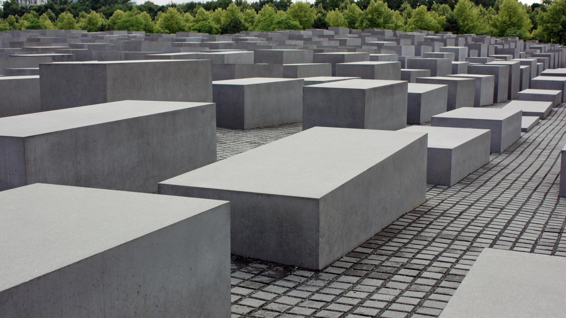 Die grauen Stehlen des Holocaust-Mahnmals in Berlin stehen auf einem großen, gepflasterten Platz.
