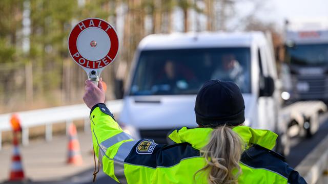 Eine deutsche Polizistin stoppt ein Auto an der Grenze zu dem Land Polen.