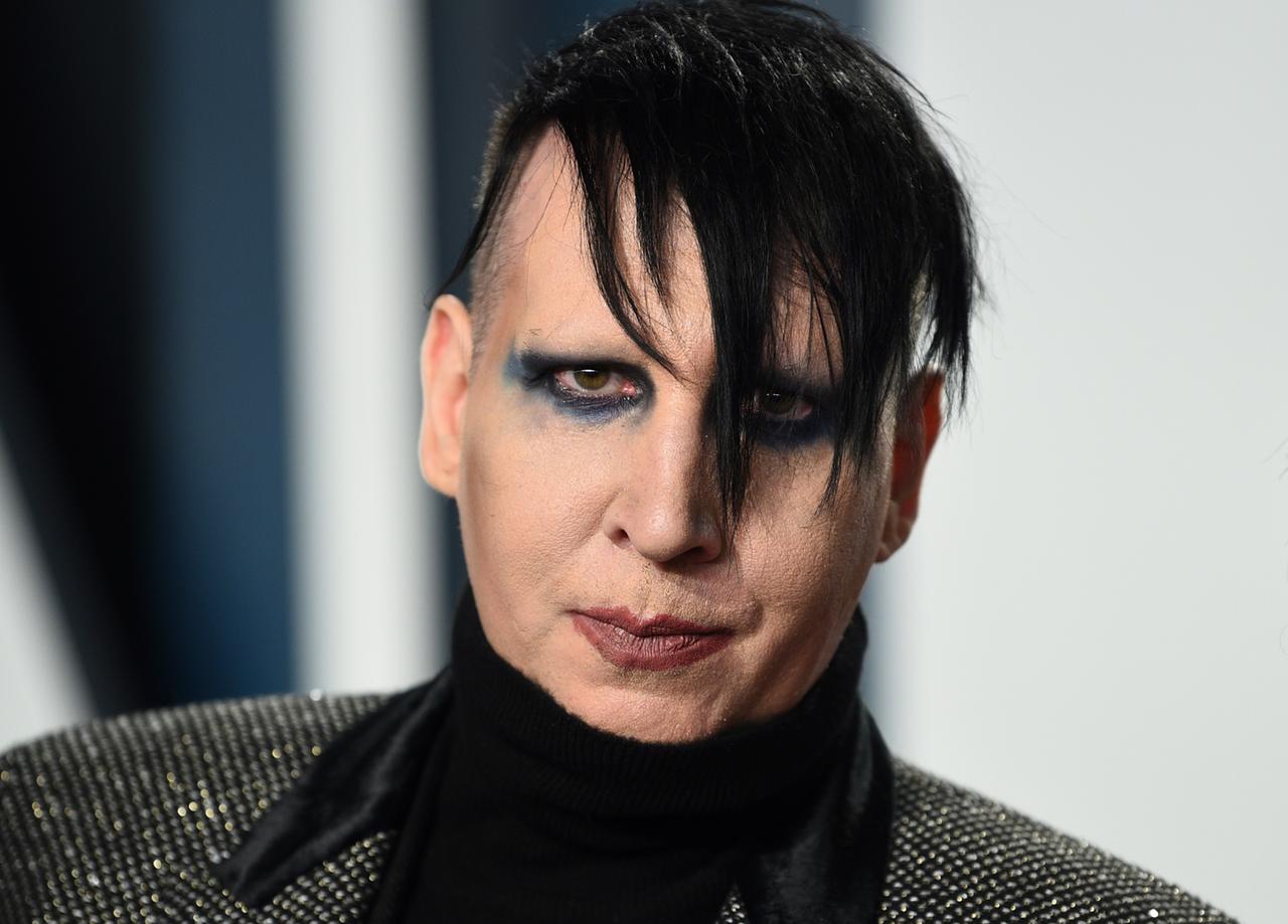 Porträt des Musikers Marilyn Manson. Schwarze Haare hängen ins Gesicht. Die Augen sind dunkel geschminkt.