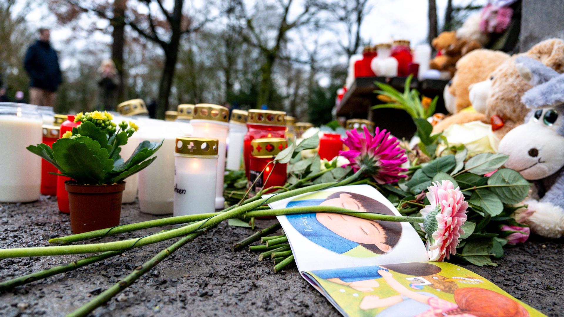 Nach der Messerattacke in Aschaffenburg liegen am Tatort Trauerkerzen, Blumen und Kuscheltiere.