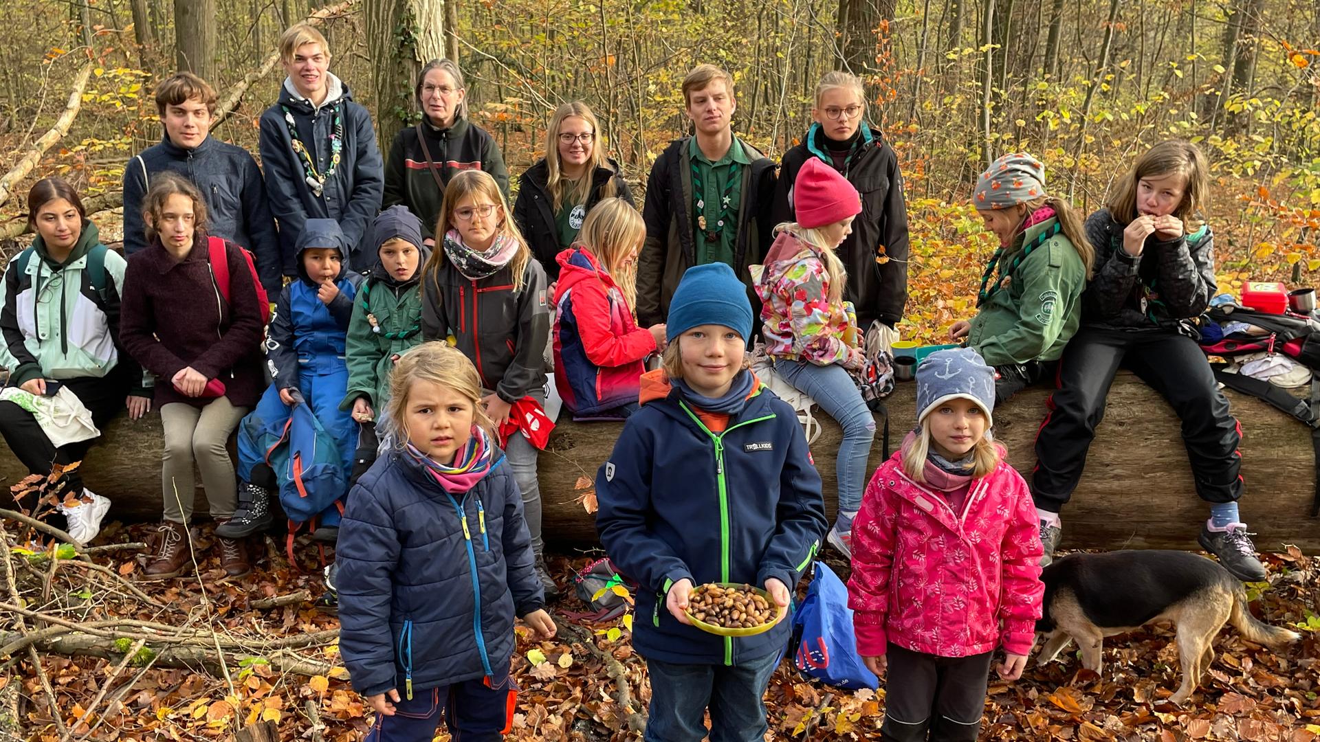 Eine Gruppe Kinder, die sich in der Waldjugend engagiert, steht im Wald. 