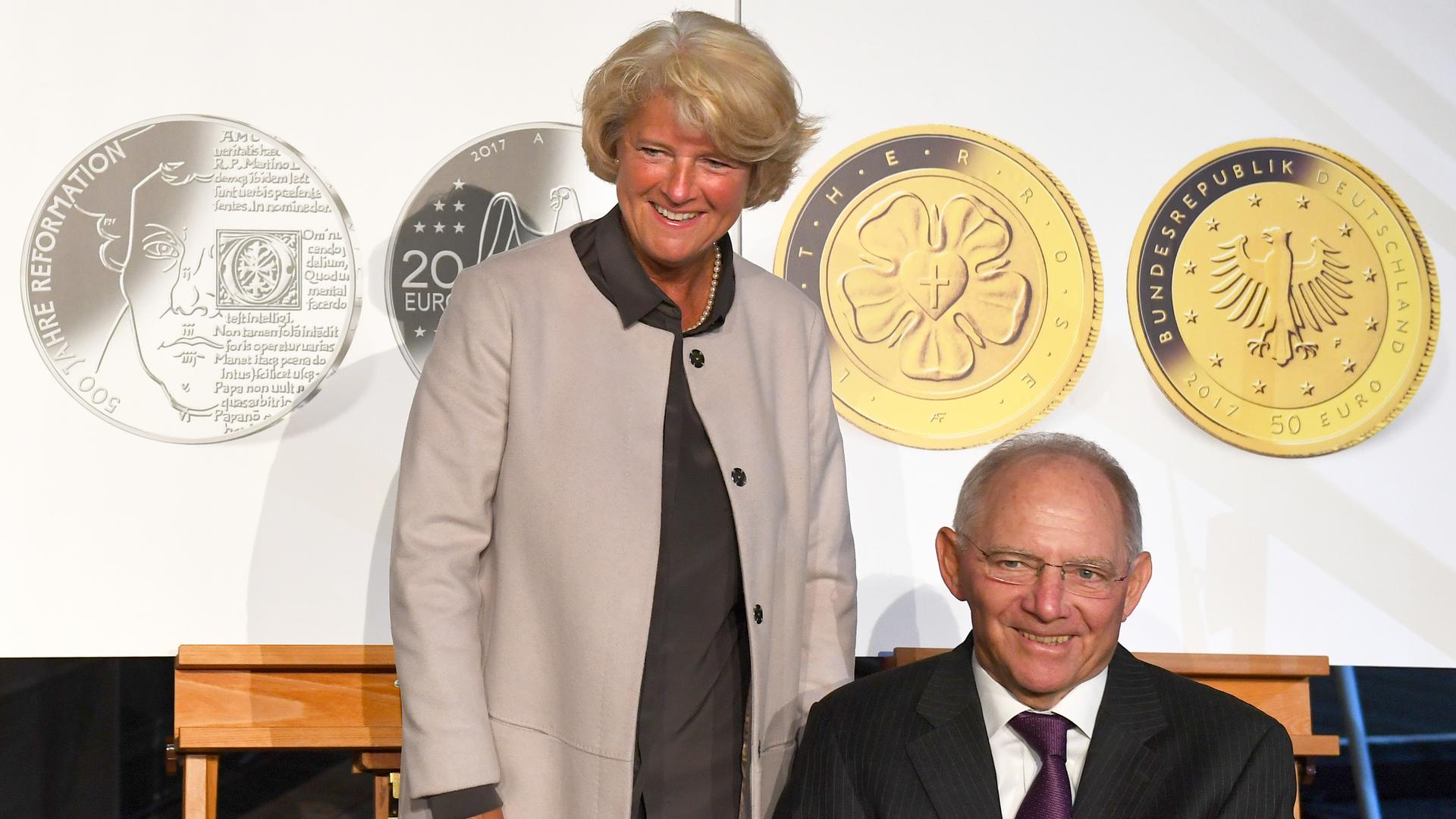 Finanzminister Wolfgang Schäuble (CDU) und Kulturstaatssekretärin Monika Grütters (CDU) posieren im Jahr 2017 während des Festaktes "500 Jahre Reformation" der Berliner Festspiele und des Martin-Gropius-Baus im Rahmen der Ausstellung "Der Luthereffekt. 500 Jahre Protestantismus in der Welt" am 25.04.2017 in Berlin vor Nachbildungen von Gedenkmünzen zum Lutherjahr. 