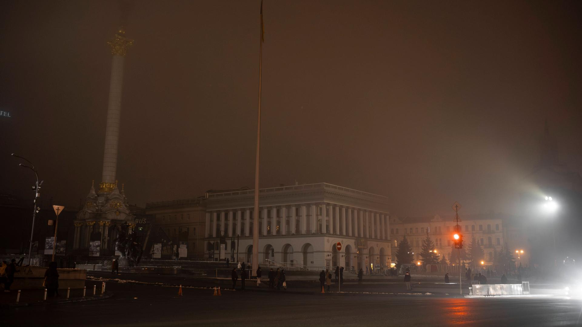 Das Unabhängigkeitsdenkmal und die Ukrainische Nationale Tschaikowsky-Musikakademie sind während eines Stromausfalls in gefrierenden Nebel gehüllt, der von generatorbetriebenen Lichtern herrührte.