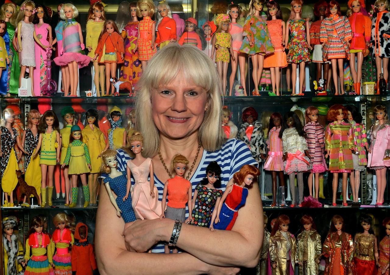 Barbiepuppen-Sammlerin Bettina Dorfmann steht vor einer Glasvitrine in ihrem Haus mit unzähligen Barbies.