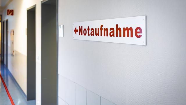 In einem Kranken-Haus hängt ein Schild. Darauf steht in roter Schrift "Not-Aufnahme".