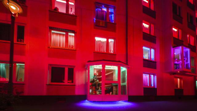 Das Foto zeigt ein rot beleuchtetes Bordell mit Prostituierten in den Fenstern in Düsseldorf.