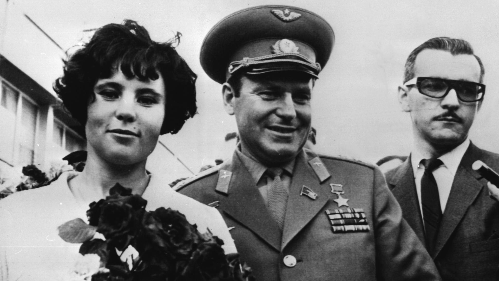 Ein Mann in Uniform und eine Frau laufen nebeneinander, sie trägt einen Blumenstrauß. Ein Mann in Uniform und eine Frau laufen nebeneinander, sie trägt einen Blumenstrauß.