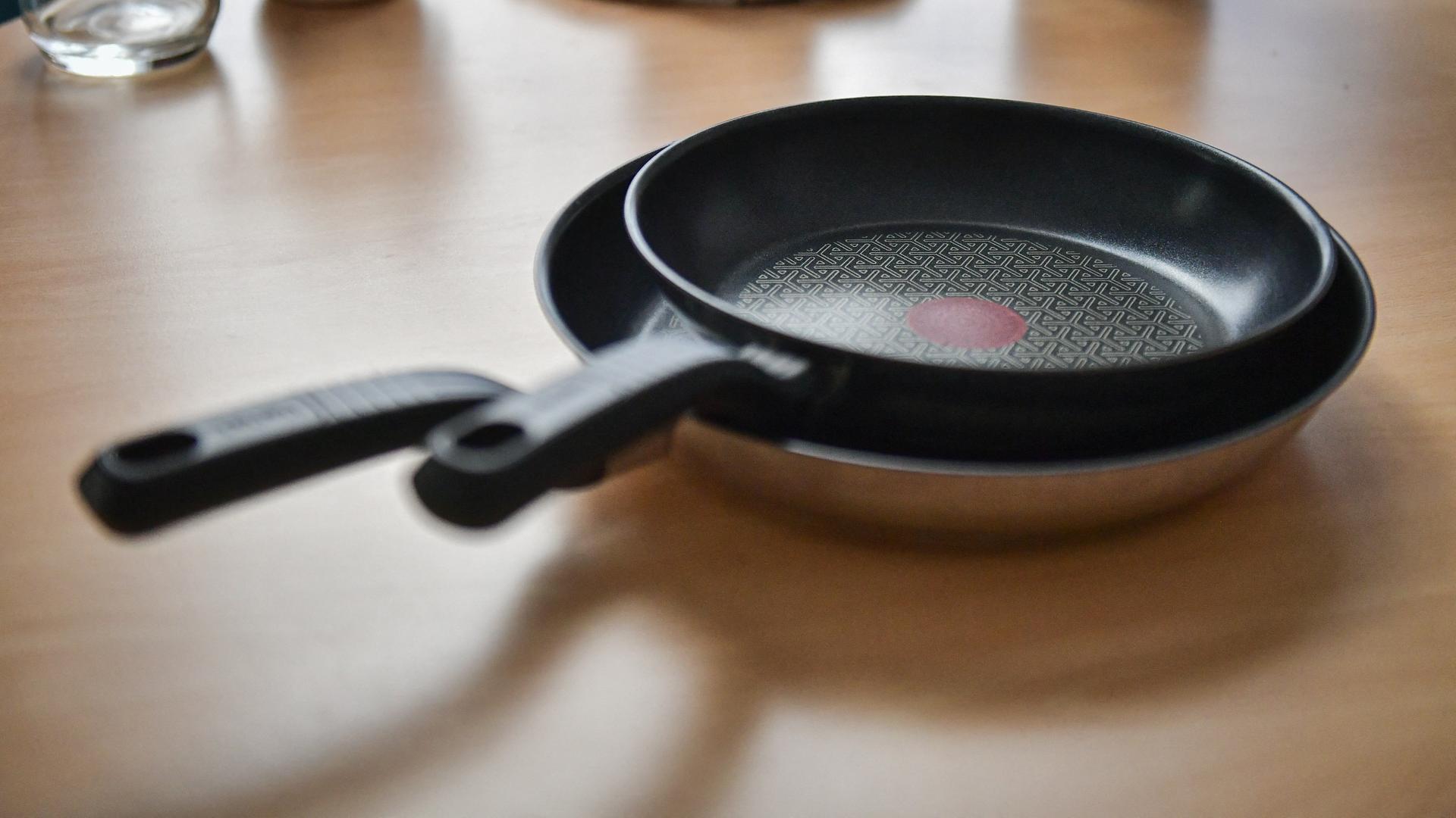 Zwei beschichtete Pfannen des Herstellers Tefal stehen auf einem Tisch.