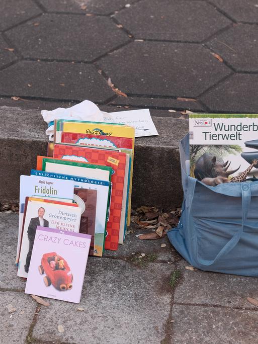 Bücher stehen zur kostenlosen Mitnahme am Bordsteinrand.