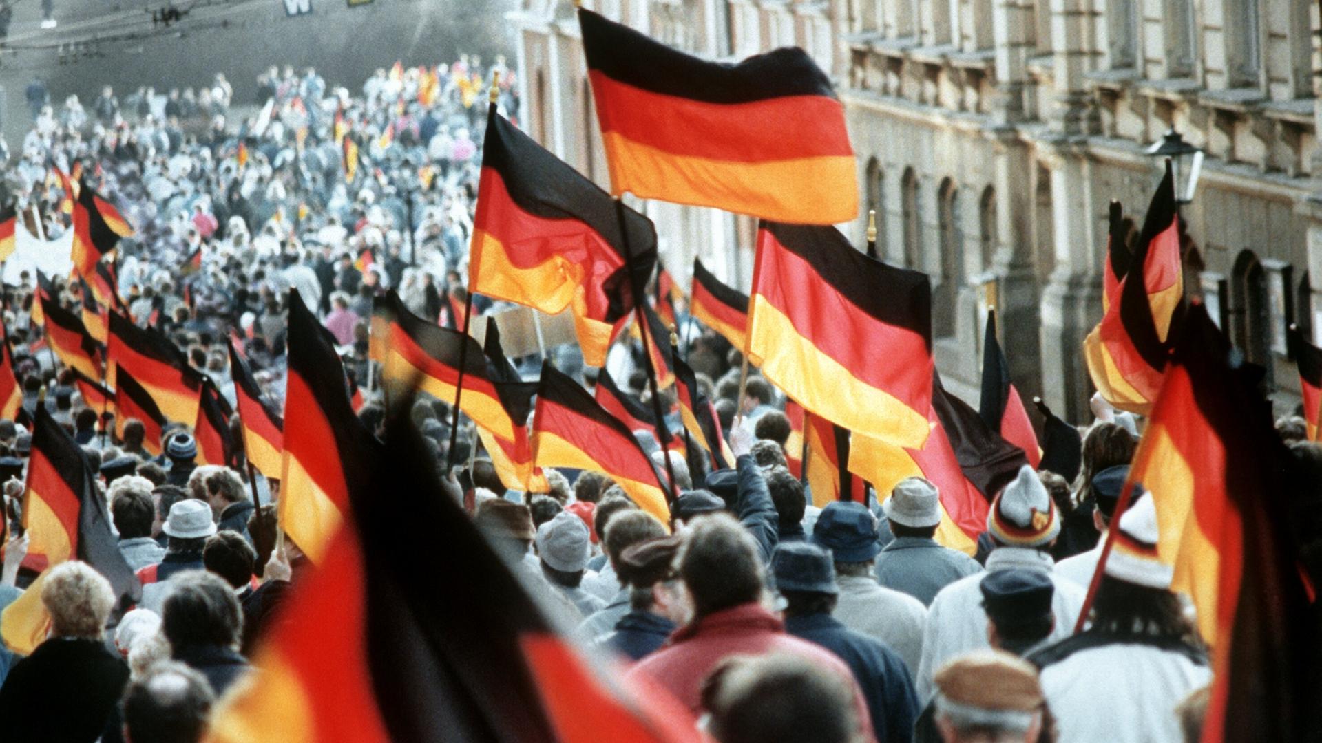 Ein Meer von Deutschlandfahnen prägt am 27.1.1990 im sächsischen Plauen die Demonstration für die deutsch-deutsche Wiedervereinigung. 