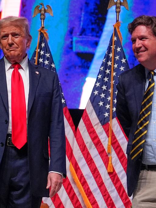 Präsident Donald Trump, damals noch Präsidentschaftskandidatin, im Gespräch mit Tucker Carlson während einer "Tucker Carlson Live Tour"-Show in der Desert Diamond Arena am 31. Oktober 2024 in Glendale, Arizona. Präsident Donald Trump, damals noch Präsidentschaftskandidatin, im Gespräch mit Tucker Carlson während einer "Tucker Carlson Live Tour"-Show in der Desert Diamond Arena am 31. Oktober 2024 in Glendale, Arizona.