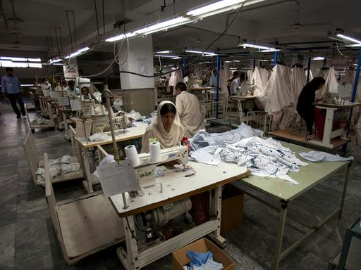 Arbeiterin in einer Textilfabrik in Pakistan, in der die Stromversorgung nur reduziert läuft. 