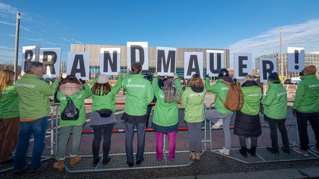 Demonstranten von Greenpeace halten das Wort Brandmauer nach oben. Als Reaktion auf das Abstimmungsverhalten der Unions-Bundestagsfraktion zur Migrationspolitik gab es am 3. Februar beim CDU-Bundesparteitag Proteste.  