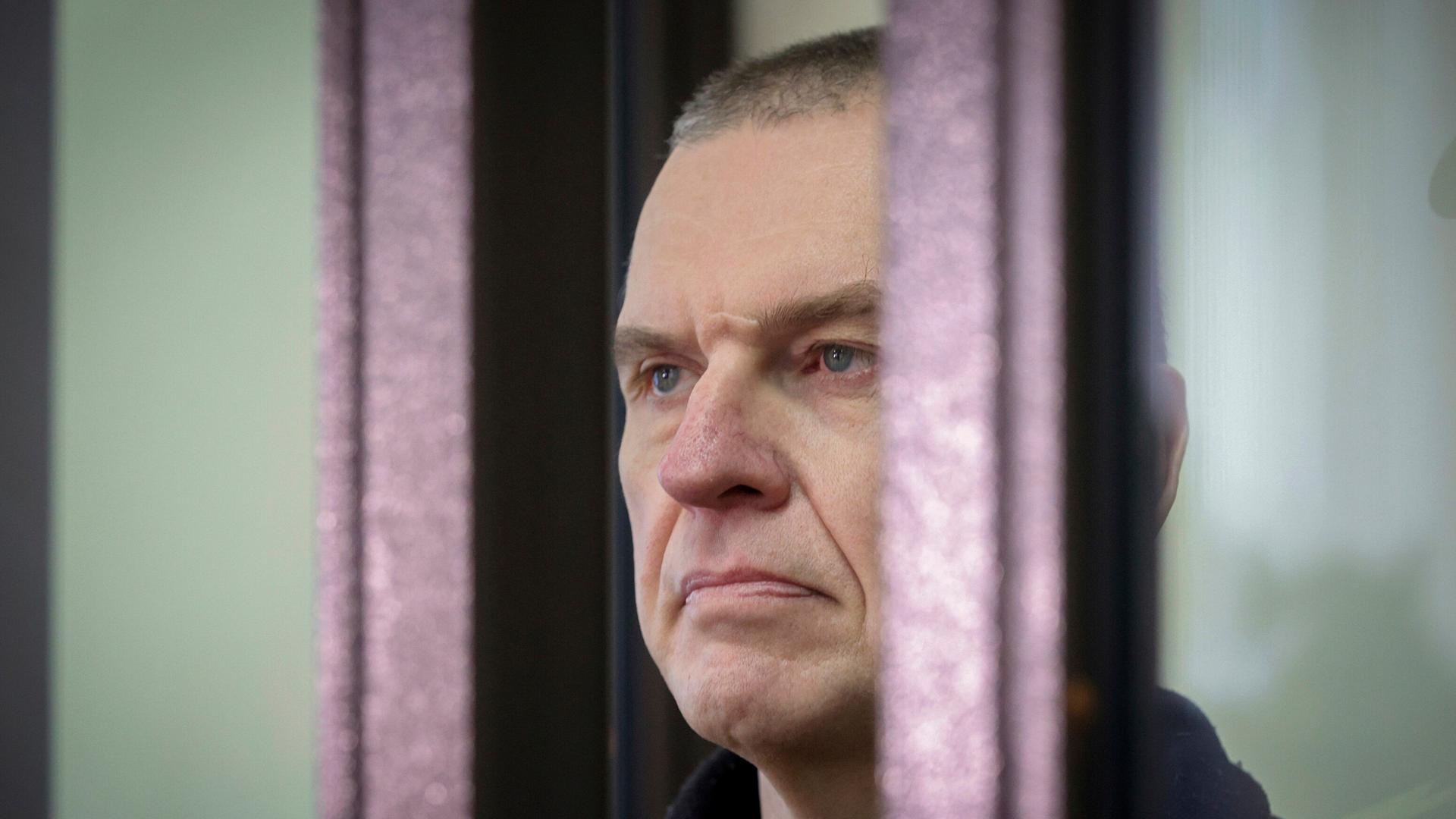 Der inhaftierte belarussische Journalist Andrzej Poczobut hinter einem Gitter. Der inhaftierte belarussische Journalist Andrzej Poczobut hinter einem Gitter.