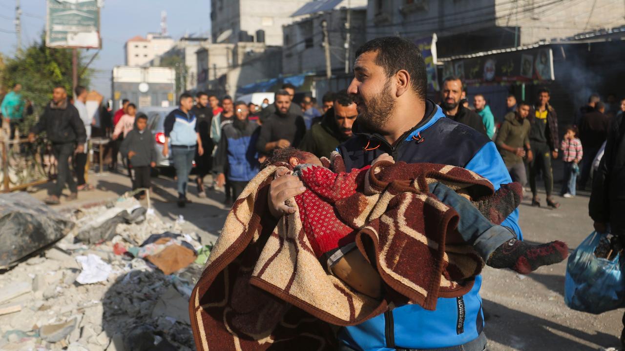 Nach einem Angriff auf Rafah: Ein Mann hält ein Kind auf den Armen.