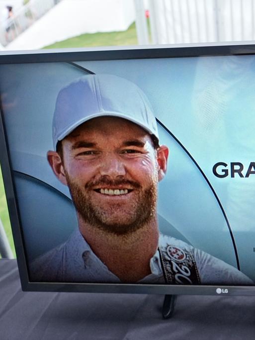 Auf einem Bildschirm am Rande eines Golfturniers wird ein Foto des verstorbenen Grayson Murray mit Geburts- und Todeshjahr gezeigt.