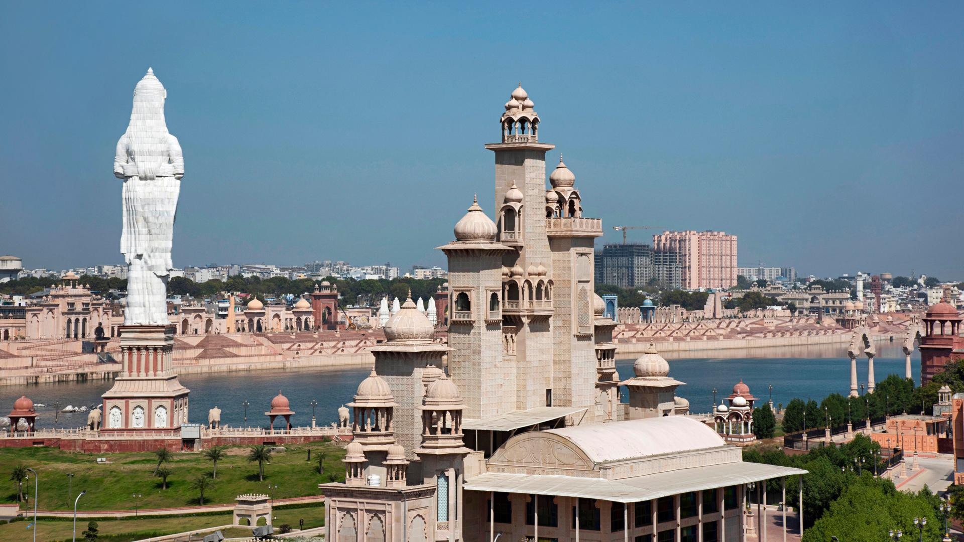 Blick auf die Stadt Kota. Im Vordergrund imposante Statuen und Gebäude, im Hintergrund der Fluss.