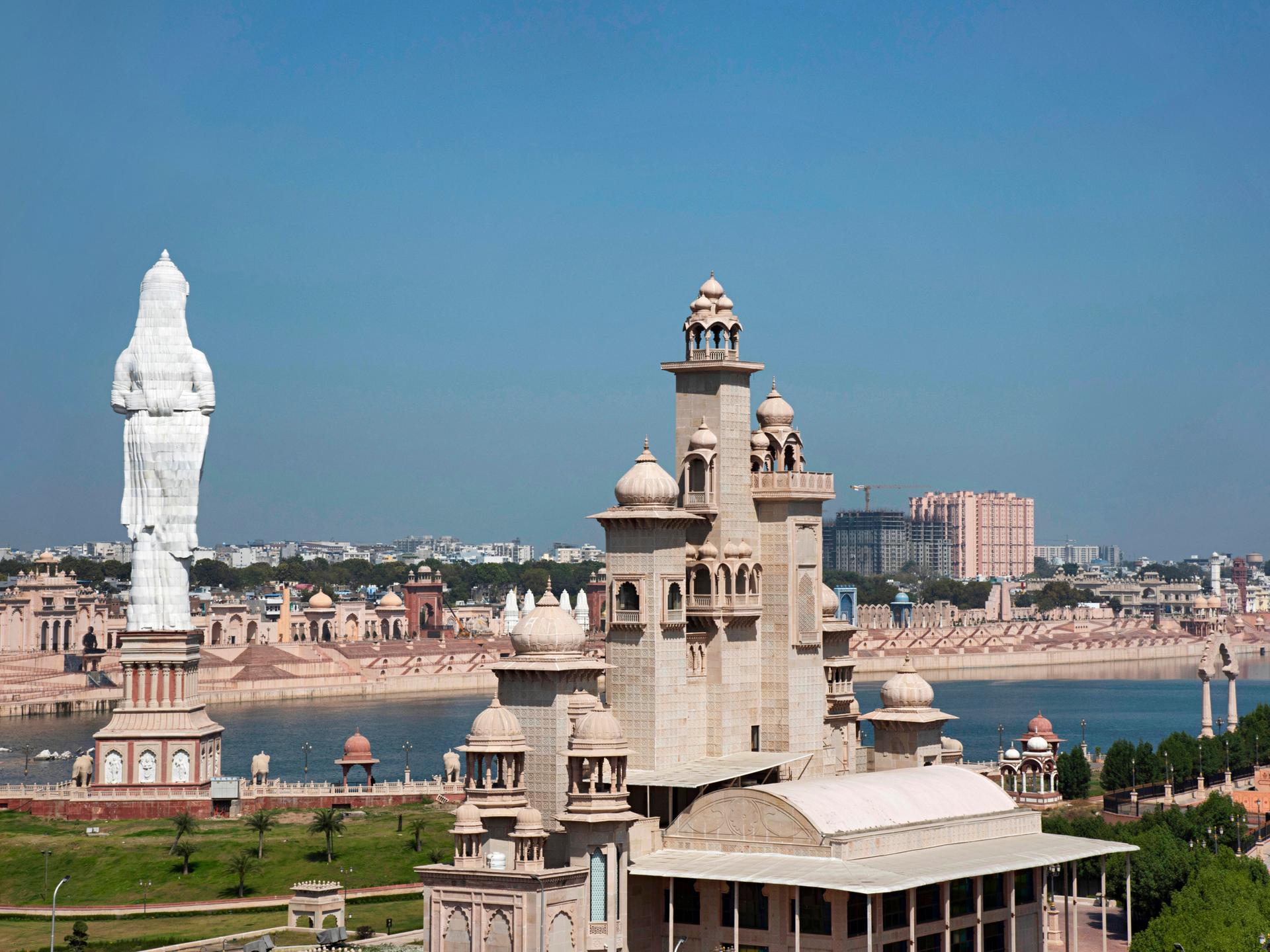 Blick auf die Stadt Kota. Im Vordergrund imposante Statuen und Gebäude, im Hintergrund der Fluss.