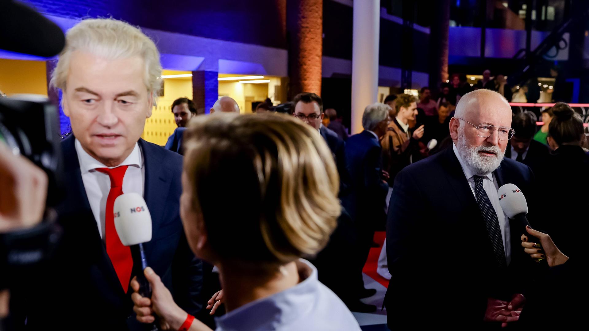 Die niederländischen Politiker Wilders und Timmermans sprechen in Presse-Mikrofone.