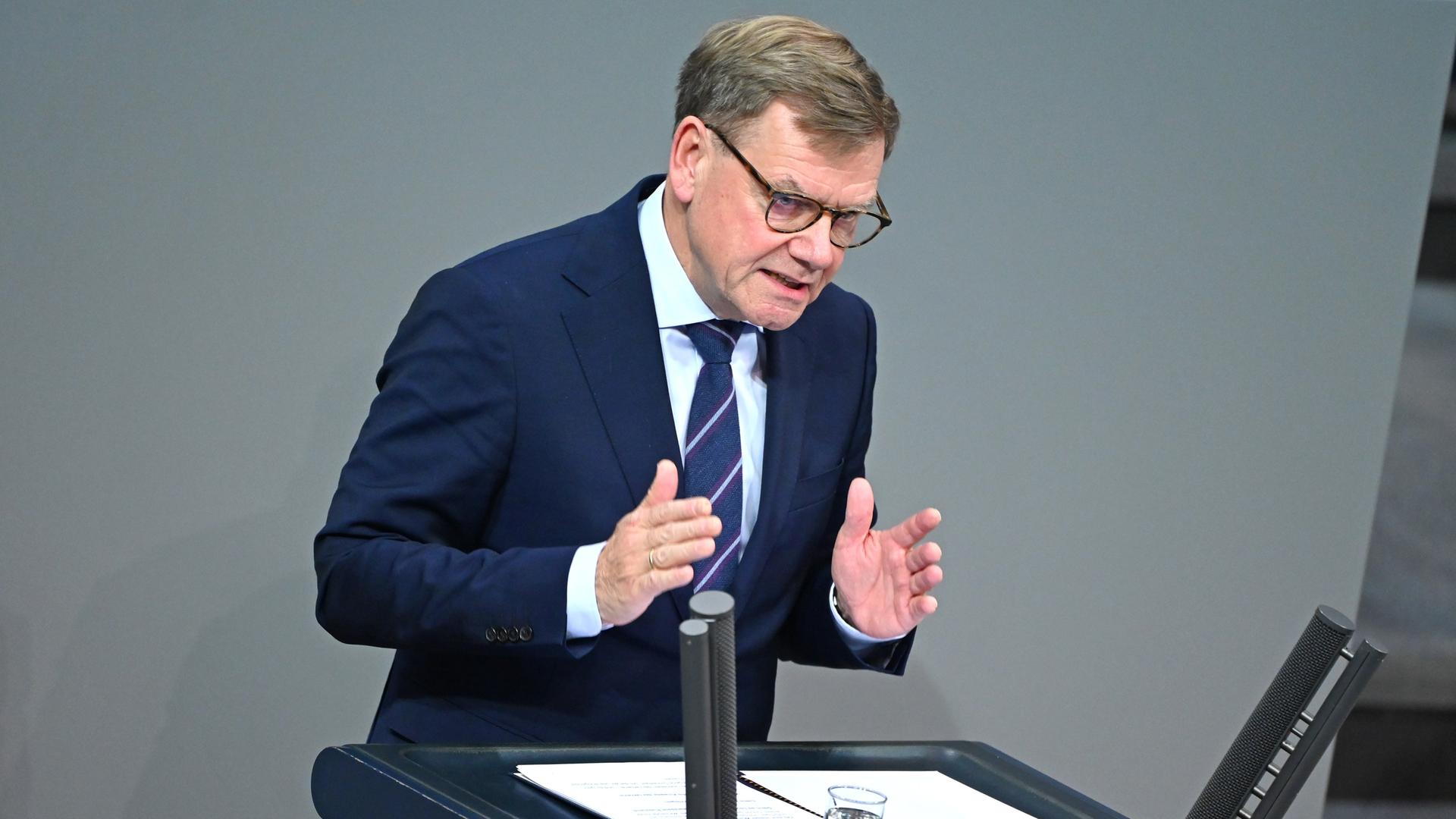 Wadephul im dunklen Jackett spricht am Rednerpult und gestikuliert mit beiden Händen.