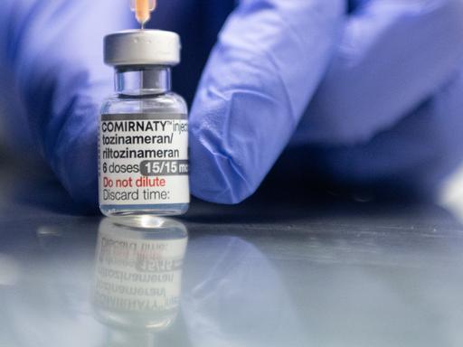 Ein Mitarbeiter zieht im Impfzentrum Mainz eine Spritze mit dem an die Omikron-BA.1-Variante angepassten Impfstoff Comirnaty von Biontech und Pfizer auf. 