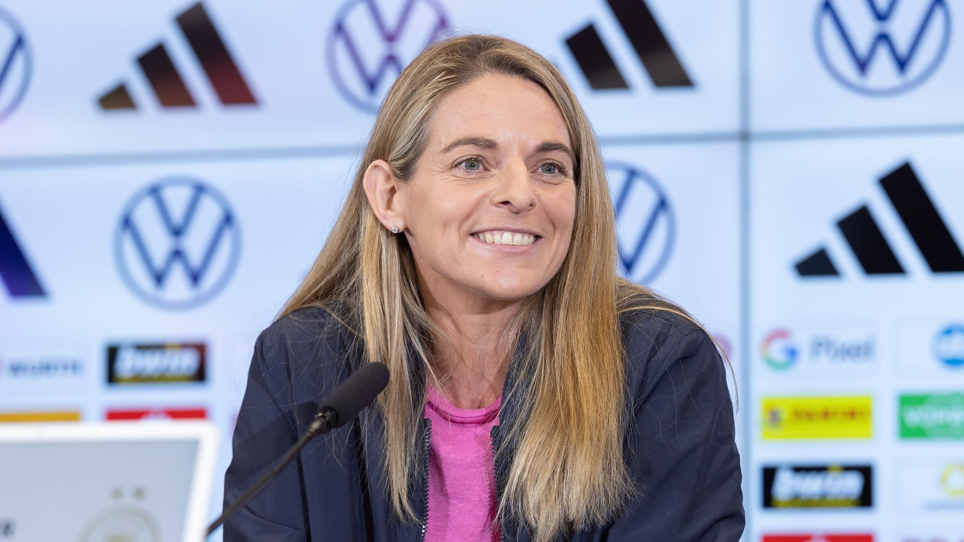 DFB-Sportdirektorin Nia Künzer spricht auf der PK. Pressekonferenz mit DFB-Sportdirektorin Nia Künzer/Kuenzer auf dem DFB-Campus in Frankfurt am Main am 11. Januar 2024. Eine Frau mit langen, blonden Haaren lächelt freundlich. DFB-Sportdirektorin Nia Künzer spricht auf der PK. Pressekonferenz mit DFB-Sportdirektorin Nia Künzer/Kuenzer auf dem DFB-Campus in Frankfurt am Main am 11. Januar 2024. Eine Frau mit langen, blonden Haaren lächelt freundlich.