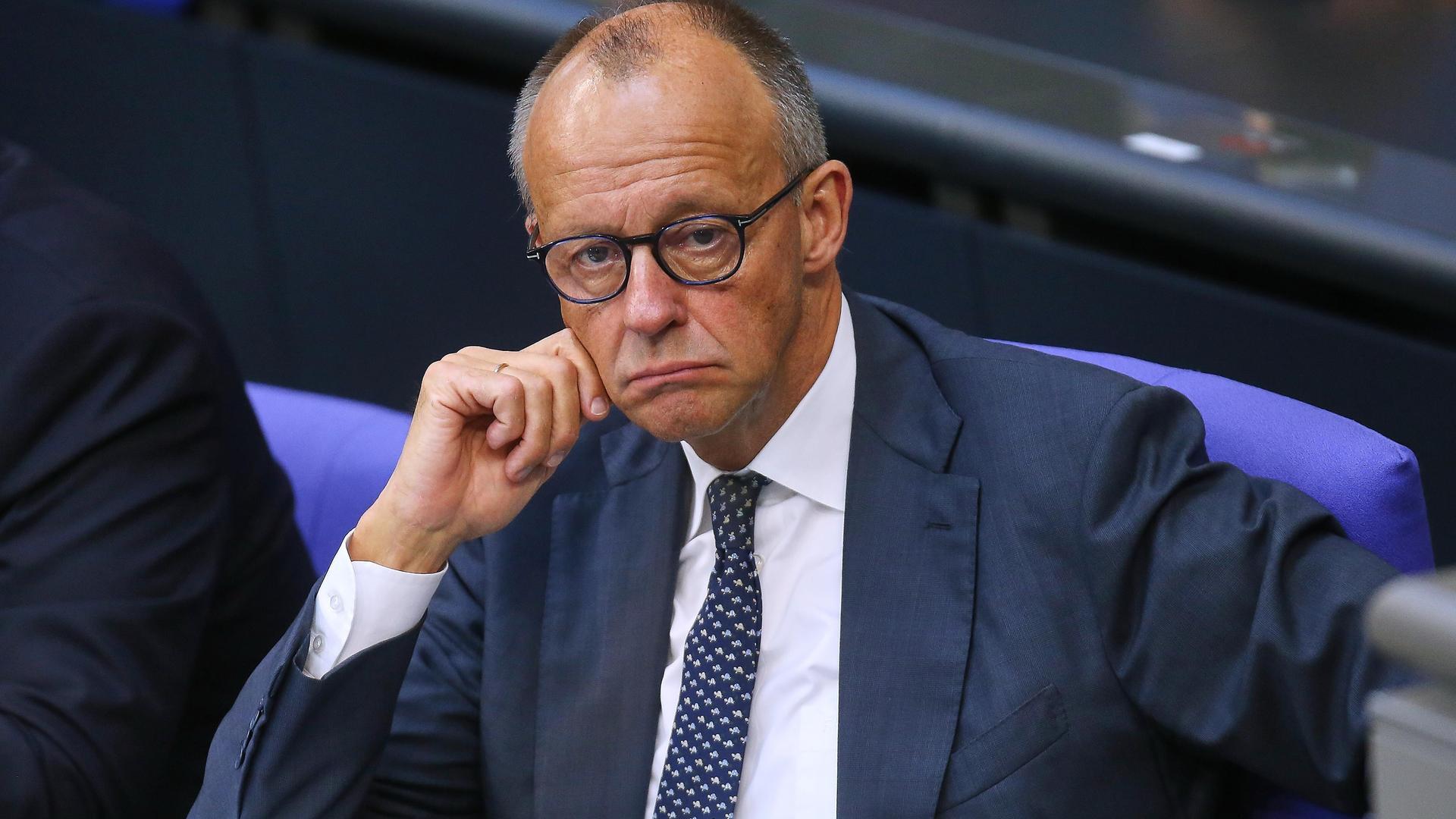 Bundeskanzler Friedrich Merz (CDU) sitzt mit heruntergezogenen Mundwinkeln im Bundestag.