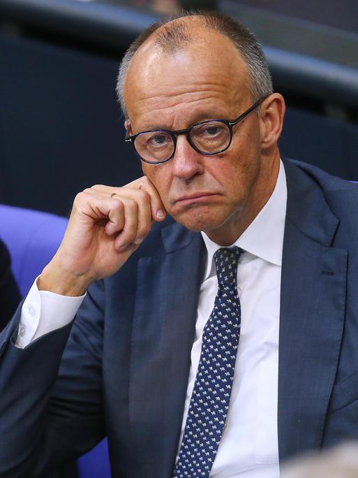 Bundeskanzler Friedrich Merz (CDU) sitzt mit heruntergezogenen Mundwinkeln im Bundestag.