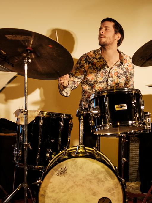 Thomas Sauerborn sitzt hinter einem großen Drum-Set und spielt.