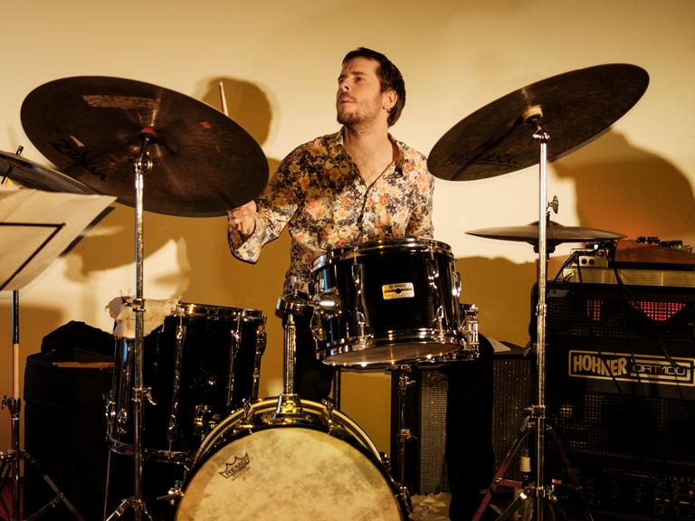 Thomas Sauerborn sitzt hinter einem großen Drum-Set und spielt.