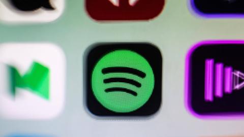 Das Bild zeigt einen kleinen Ausschnitt eines Smartphone-Bildschirms, auf dem drei App-Icons zu sehen sind. Die mittler App ist das Logo von Spotify.
