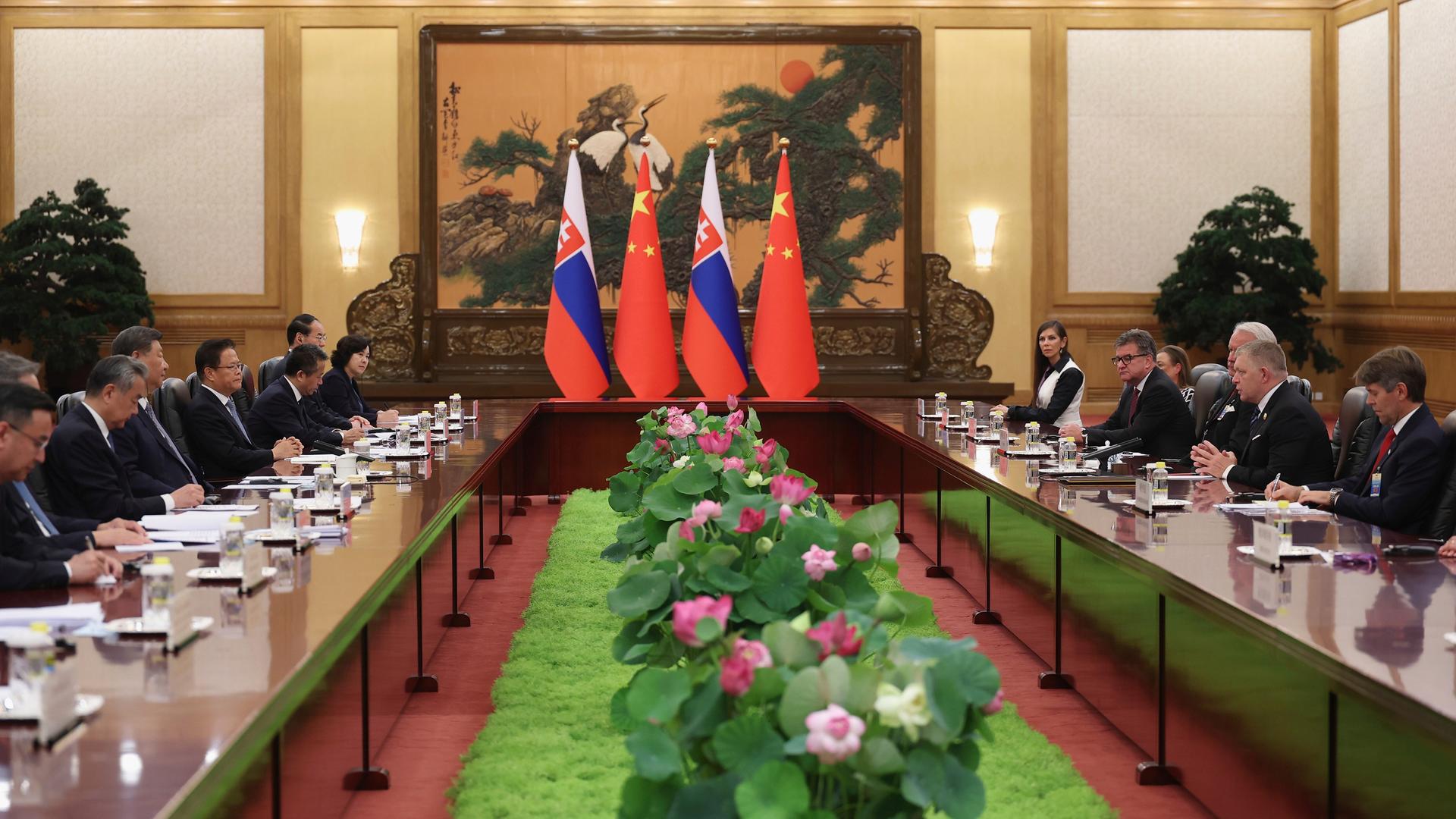 Ministerpräsident Fico sitzt mit seinen Mitarbeitern auf der rechten Seite eines langen, rechteckigen Tisches, Chinas Präsident Xi auf der linken Seite. Ministerpräsident Fico sitzt mit seinen Mitarbeitern auf der rechten Seite eines langen, rechteckigen Tisches, Chinas Präsident Xi auf der linken Seite.