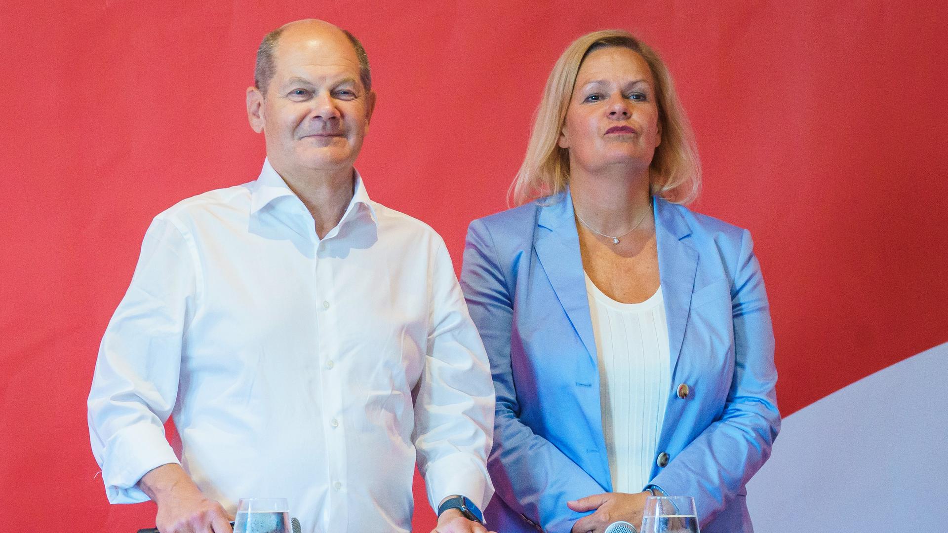 Bundeskanzler Olaf Scholz steht gemeinsam mit Nancy Faeser, Spitzenkandidatin der SPD für die anstehende Hessenwahl, auf einem Podium.