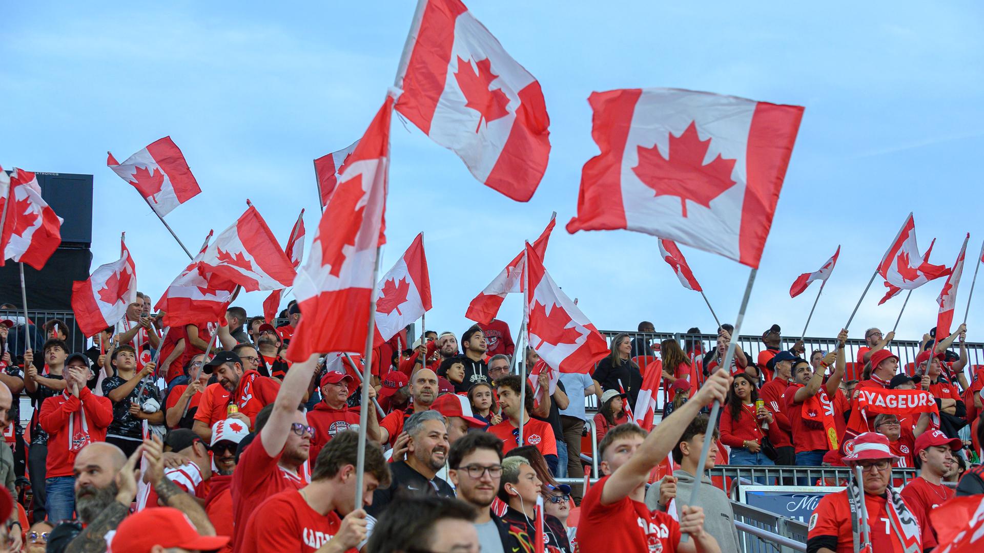 Kanadische Fans schwenken Fahnen und jubeln auf den Tribünen vor einem Länderspiel in Toronto, Kanada.