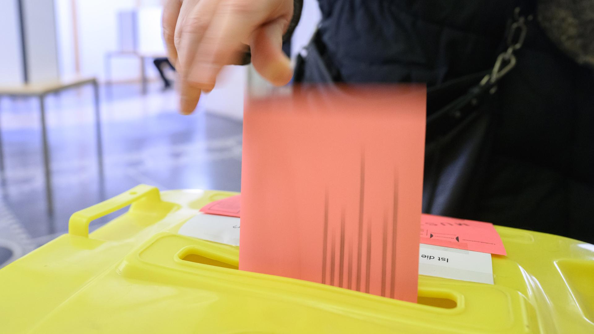 Eine Person wirft ihren Wahlzettel für die Bundestagswahl 2025 in der Briefwahlstelle im Neuen Rathaus in eine Urne. In vielen Städten können Wähler bei den Briefwahlstellen Briefwahl beantragen oder sofort ihre Wahlunterlagen ausfüllen und abgeben.