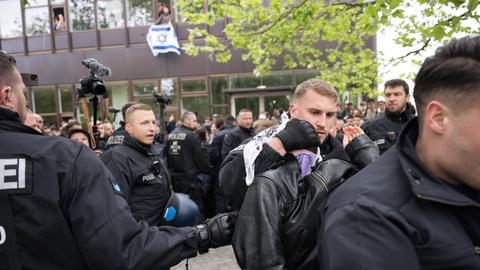 Polizeibeamte bringen während einer propalästinensischen Demonstration der Gruppe "Student Coalition Berlin" auf dem Theaterhof der Freien Universität Berlin außerhalb des Camps Demonstranten weg. 