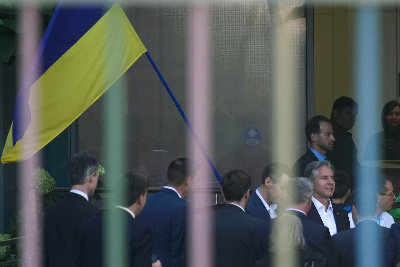 US-Außenminister Blinken kommt mit Begleitern an einem Kinderhospital in Kiew in der Ukraine an. Im Hintergrund eine ukrainische Flagge.