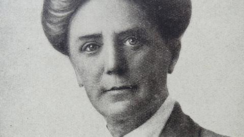 Historische Porträtfotografie von Dame Ethel Mary Smyth mit hoch geschlossenem Kragen und hochgesteckten Haaren mit direktem, offenen Blick in die Kamera.