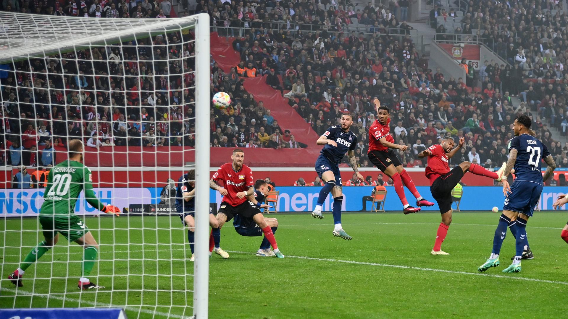 Kopfballduell im Spiel Leverkusen-Köln. Mehrere Spieler beider Mannschaften sind vor dem Tor. Kopfballduell im Spiel Leverkusen-Köln. Mehrere Spieler beider Mannschaften sind vor dem Tor.