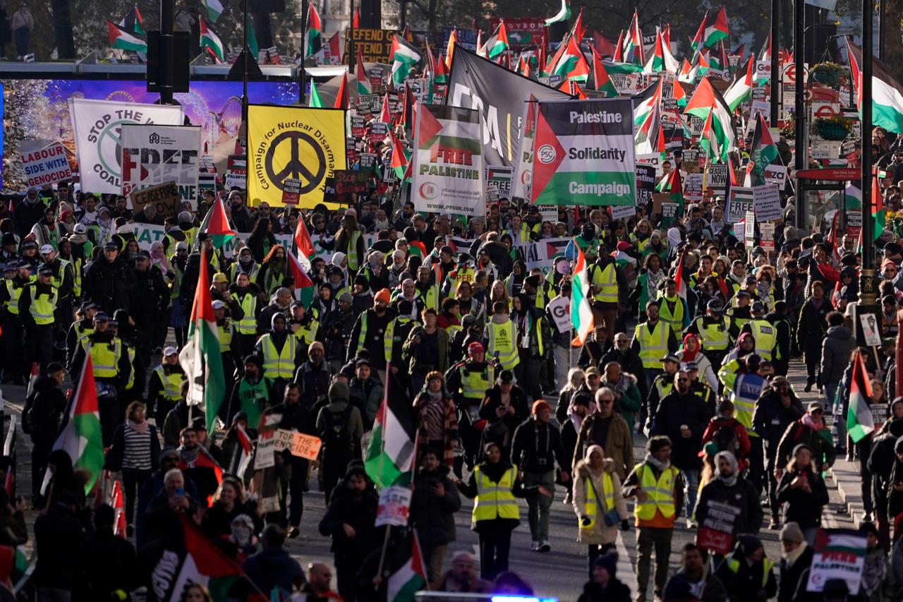 Demonstranten halten Fahnen und Plakate, während sie an einer pro-palästinensischen Demonstration in London teilnehmen