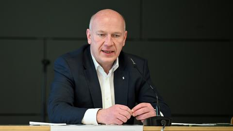 Berlins Bürgermeister Kai Wegner sitzt an einem Tisch und spricht.