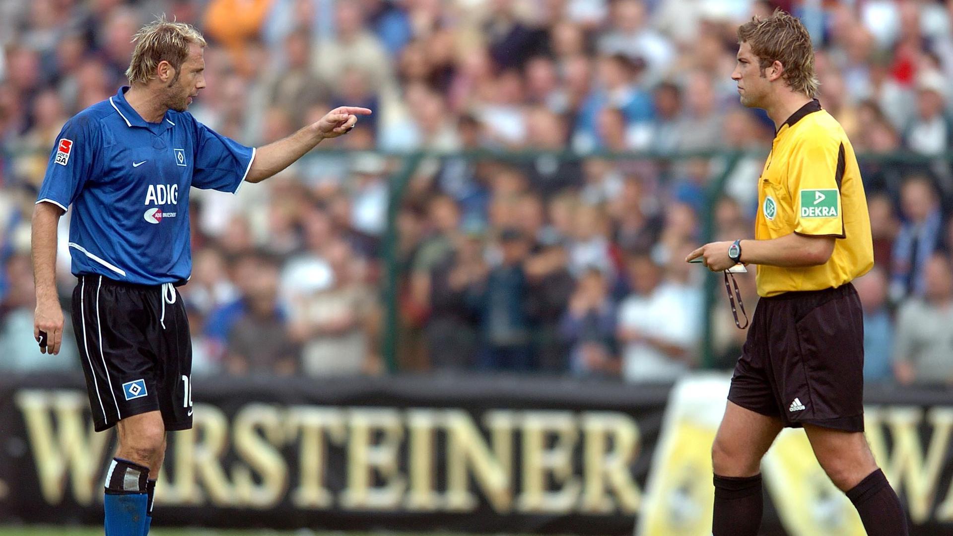 Der Hamburger Spieler Sergej Barbarez (links) diskutiert mit Schiedsrichter Robert Hoyzer in Paderborn im DFB-Pokalspiel, 2004.