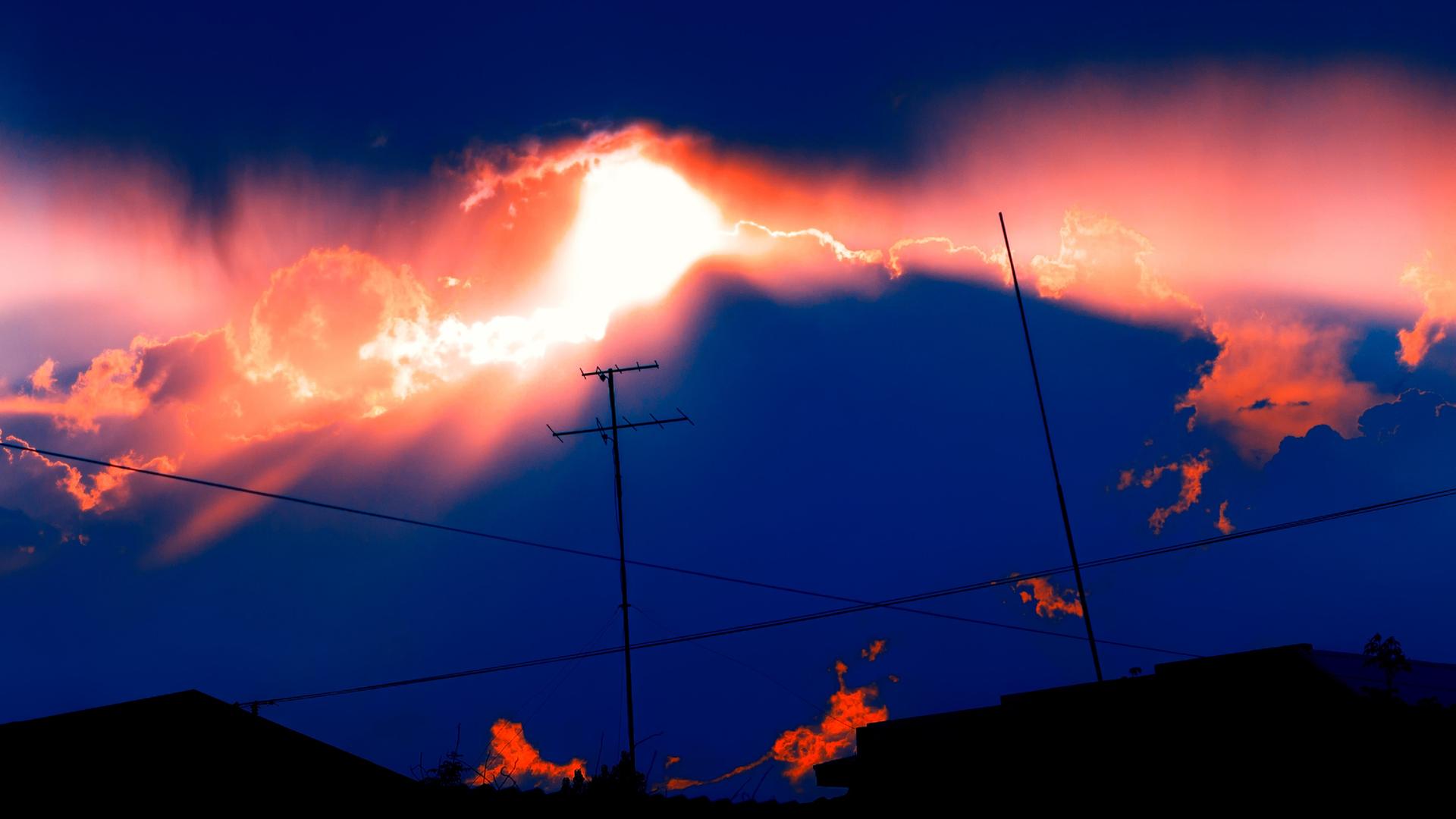 Eine Antenne vor Gewitterwolken mit Sonnenuntergang.