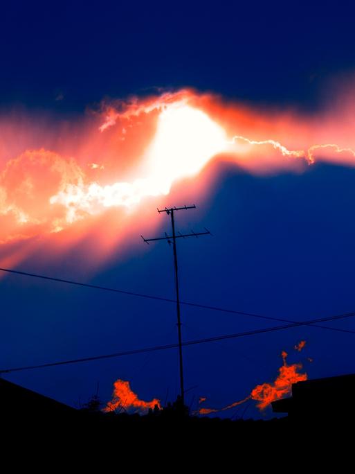 Eine Antenne vor Gewitterwolken mit Sonnenuntergang.