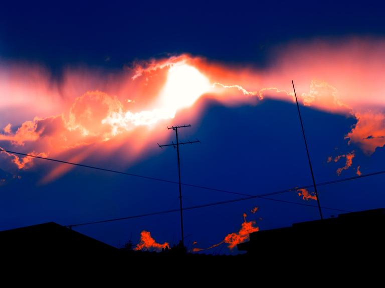 Eine Antenne vor Gewitterwolken mit Sonnenuntergang.