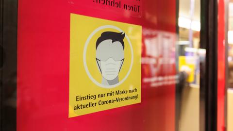 An der Tür eine Straßenbahn wird auf die Maskenpflicht hingewiesen.