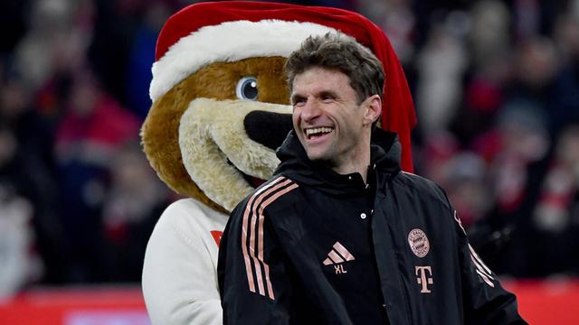 Der Bayern-Spieler Thomas Müller feiert mit dem Maskottchen Berni.