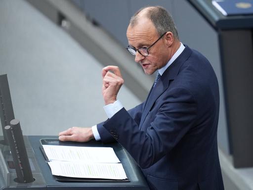 CDU-Kanzlerkandidat Friedrich Merz bei einer Rede im Deutschen Bundestag am Rednerpult. Mit einer Geste seiner Hand betont er seine Worte.